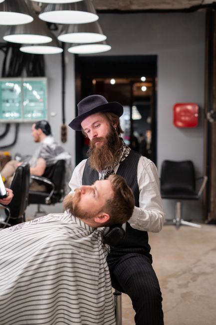 Barber trimming and shaping a client's beard