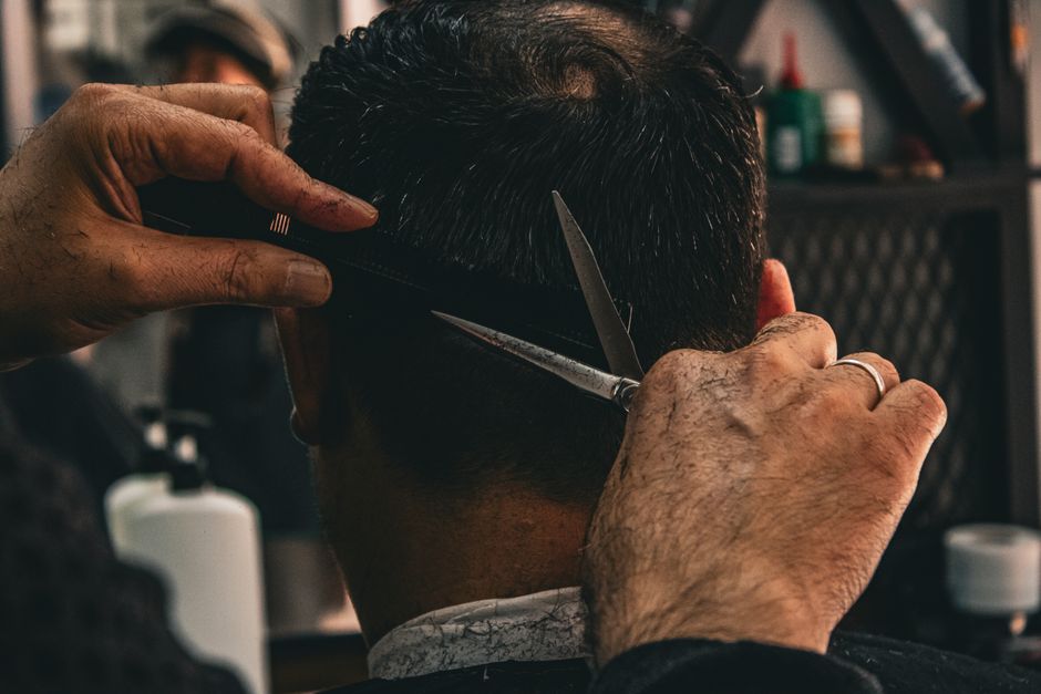Barber giving a client a precise scissor and comb haircut